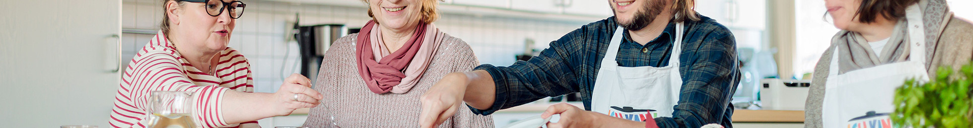 Foto: Foto: Sarah Wiener Stiftung | photothek Drei Frauen und ein Mann essen gemeinsam.